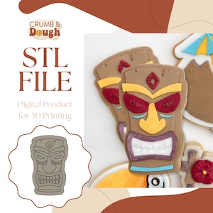 Peut inclure: FICHIER STL Produit numérique pour l'impression 3D. Un téléchargement numérique d'un emporte-pièce tiki en forme de masque à imprimer en 3D. L'image montre un emporte-pièce tiki en forme de masque brun avec un nez jaune, des yeux rouges et une bouche blanche. L'emporte-pièce est entouré de biscuits décorés.