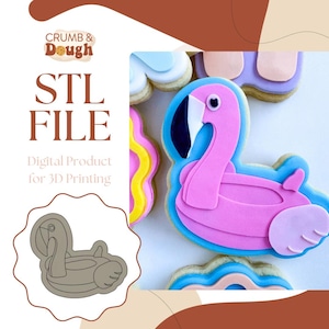 Puede incluir: Un archivo STL digital para la impresión 3D de un cortador de galletas con forma de flotador de flamenco para piscina. La imagen muestra una galleta con forma de flotador de flamenco para piscina decorada con glaseado rosa y azul.