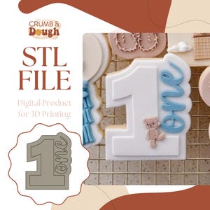 Può includere: Un file STL digitale per la stampa 3D di uno stampino per biscotti a forma di numero uno con la parola "one" scritta accanto. Lo stampino per biscotti è grigio e lo sfondo è una griglia bianca.