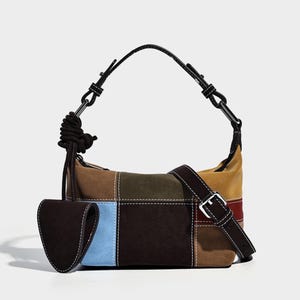 May include: A patchwork shoulder bag with a variety of colors including brown, blue, and yellow. The bag has a black strap and a small attached pouch. The bag has a buckle closure and a rope detail on the handle.