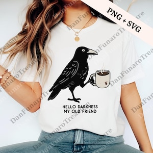 May include: White t-shirt featuring a black crow holding a coffee mug. The crow has a detailed design and is holding a beige mug with coffee. The text "HELLO DARKNESS MY OLD FRIEND" is below the crow.