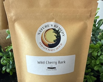 May include: A brown paper bag with a white label that reads "Wild Cherry Bark" and "Prunus Serotina". The bag has a circular sticker with the words "Nature's Remedy Apothecary". The bag is labeled "1 oz".