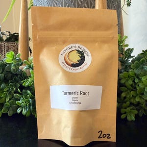 Puede incluir: Una bolsa de papel marrón etiquetada como "Nature's Remedy apothecary" que contiene polvo de raíz de cúrcuma. La bolsa tiene una etiqueta blanca con el texto "Turmeric Root, powder, Organic, Curcuma Longa." La bolsa está marcada "2oz".
