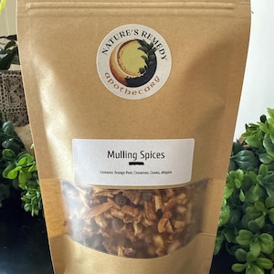 May include: A brown paper bag of mulling spices with a clear window. The label reads "Mulling Spices" and lists ingredients. A round sticker with the words "Nature's Remedy Apothecary" is on the bag.