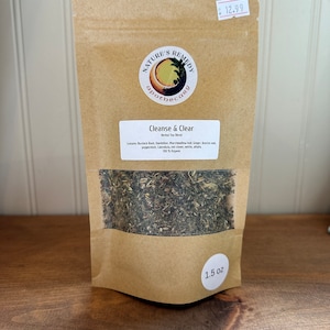 Puede incluir: Una bolsa de papel marrón con una etiqueta blanca que dice "Cleanse & Clear Herbal Tea Blend". La bolsa contiene una mezcla de hierbas secas y tiene una etiqueta blanca en la parte inferior que dice "1.5 oz".