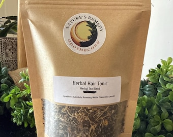 May include: A brown paper bag of herbal hair tonic. The bag has a clear window showing the tea blend inside. The label reads "Herbal Hair Tonic, Herbal Tea Blend." The ingredients listed are calendula, rosemary, nettle, chamomile, and lavender. The bag is 42.5 grams.