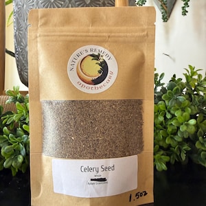 May include: A brown paper bag of celery seeds with a clear window. The bag has a circular label that reads "Nature's Remedy apothecary". The label below the window reads "Celery Seed Whole Apium Graveolens". The bag is labeled "1.5 oz".