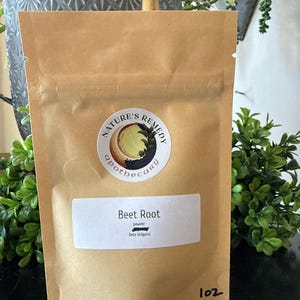 May include: A brown paper bag labeled "Nature's Remedy Apothecary" containing beet root powder. The label reads "Beet Root powder Beta Vulgaris". The bag is sealed and has the number "102" printed on the bottom right.