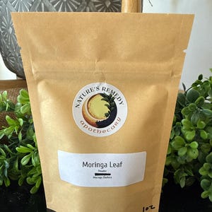 May include: A brown paper pouch with a white label that reads "Moringa Leaf Powder". The pouch has a circular sticker with the words "Nature's Remedy apothecary". The pouch contains 1 oz of product.