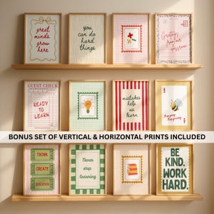 May include: A collection of framed prints with inspirational quotes and designs. The prints feature various colors, patterns, and text, including phrases like "Great minds grow here" and "You can do hard things." The prints are displayed on wooden shelves.