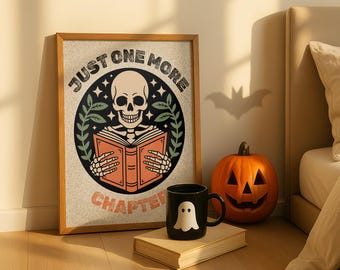 May include: A framed print with the text "JUST ONE MORE CHAPTER" featuring a skeleton reading a book. A black mug with a white ghost design and a carved pumpkin are also visible.