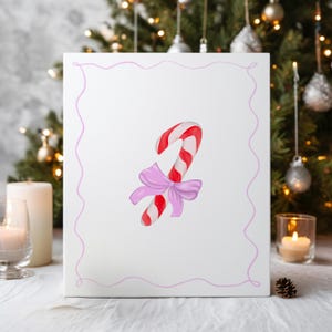 May include: A white canvas print featuring a watercolor illustration of a red and white striped candy cane with a pink bow. The artwork is framed with a pink wavy border, perfect for holiday decor.