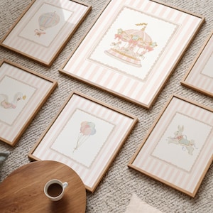 Pode incluir: Seis impressões de arte emolduradas com ilustrações caprichosas. As impressões apresentam um balão de ar quente, um carrossel, um cisne, uma bailarina, balões e um coelho. Cada impressão tem um fundo listrado rosa e uma moldura de madeira. As impressões são exibidas em um tapete de cor neutra.