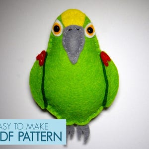 May include: A green felt parrot with a yellow head, red cheeks, and gray beak. The parrot is a sewing pattern for a plush toy. The text "EASY TO MAKE PDF PATTERN" is at the bottom of the image.