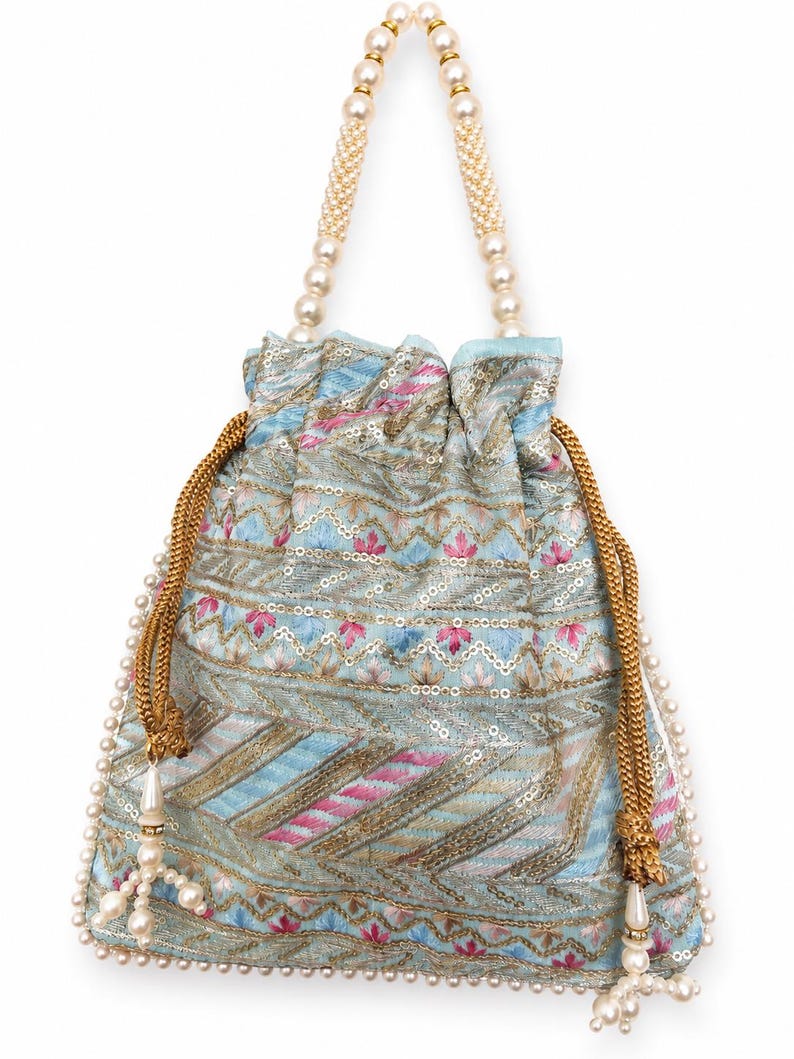 May include: A light blue drawstring bag with a floral and geometric pattern in pink, gold, and blue. The bag has a beaded handle and a beaded trim along the bottom. The drawstring is gold with a pearl tassel.