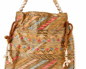 Puede incluir: Un bolso tipo saco con cordón en tono dorado que presenta un intrincado bordado en hilo rosa, azul y dorado. El bolso está adornado con hileras de pequeñas perlas blancas artificiales en los bordes y un asa de una sola hilera de perlas.
