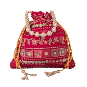 May include: A fuchsia drawstring pouch featuring intricate embroidery, small circular mirrors, and a handle made of large white faux pearls. The bag is cinched with gold-coloured braided cords that end in decorative pearl-accented tassels at the bottom.