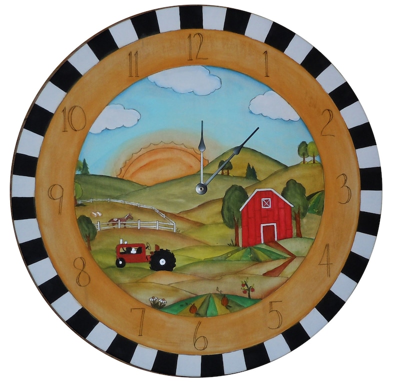 May include: A round wooden clock with a black and white striped frame. The clock face features a painted scene of a farm with a red barn, a tractor, and a sunrise. The numbers 1 through 12 are painted around the edge of the clock face.