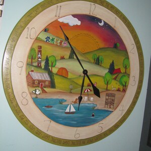 May include: A round wooden clock with a painted scene of a lake, hills, and a sunset. The clock face has Roman numerals and a green, yellow, and brown border with text that reads "The Gang That's All True Blue You Take The Pep From A Pepsi Cola You Take The Luck From A Lucky Strike You Take The Zip From A Talon Zipper You Take The Gleam From An Electric Light Electric Light And When You Put Them All Together With The Aid Of String And Skin And Get That Gang Mom Camp Arrowhead".