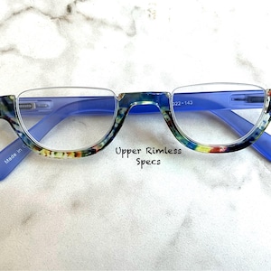 May include: Upper rimless eyeglasses with blue frames and temples. The upper rims have a colorful, speckled pattern. The text "Upper Rimless Specs" is printed below the glasses.