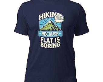 May include: Navy blue t-shirt with a graphic featuring a mountain scene and the text "HIKIN' BECAUSE FLAT IS BORING." A speech bubble says, "WHY DID I THINK THIS IS A GOOD IDEA?" The design is in shades of blue, green, and white.