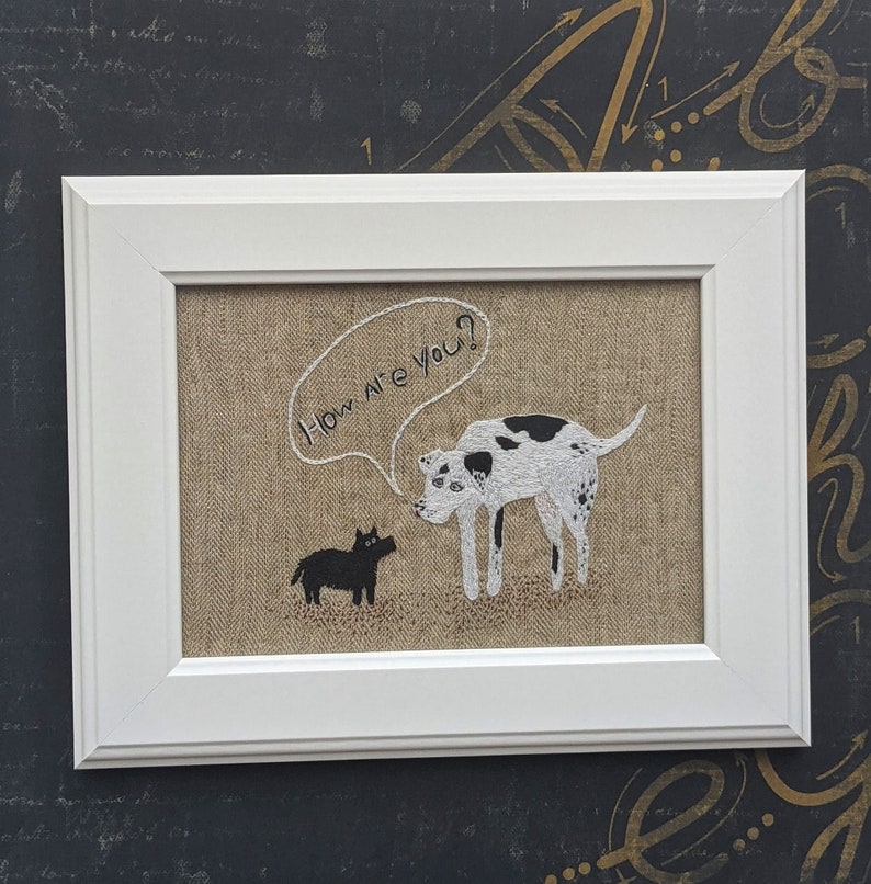 May include: A white framed embroidery with a black and white dog asking a black dog "How are you?" in a speech bubble.
