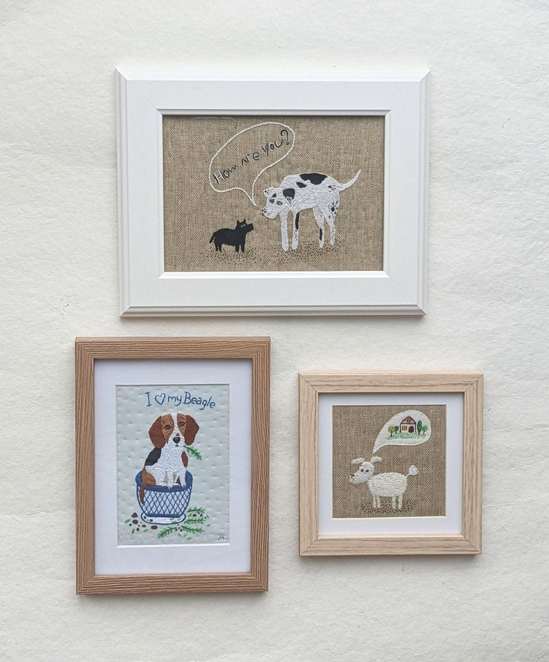 May include: Three framed embroidery pieces featuring dogs. The top frame shows a black and white dog with a speech bubble saying "How are you?" The middle frame shows a beagle in a blue cup with the text "I &hearts; my Beagle". The bottom frame shows a white dog with a speech bubble showing a house.