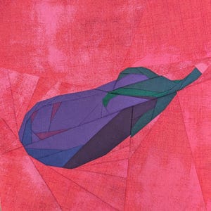 May include: A fabric quilt block featuring a pieced eggplant design in shades of purple and dark green, set against a vibrant pink background with a textured, mottled pattern. The eggplant is constructed from geometric fabric segments.