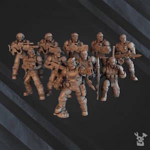 May include: A group of miniature figurines of soldiers in combat gear. The figures are in various poses, holding rifles and other weapons. The color is a muted brown, with details like helmets, vests, and pouches.