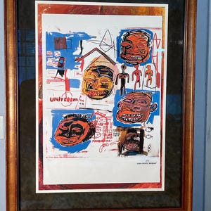 Puede incluir: Obra de arte enmarcada con un collage de rostros y símbolos abstractos en naranja, rojo, azul y blanco. La obra incluye el texto "UNIVERSAL" y la firma del artista, Jean-Michel Basquiat.