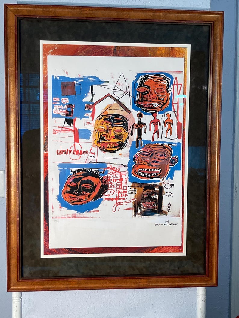 K&ouml;nnte beinhalten: Gerahmtes Kunstwerk mit einer Collage aus abstrakten Gesichtern und Symbolen in Orange, Rot, Blau und Wei&szlig;. Das Kunstwerk enth&auml;lt den Text "UNIVERSAL" und die Signatur des K&uuml;nstlers Jean-Michel Basquiat.