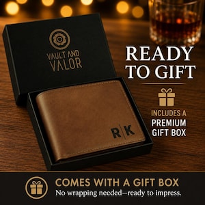 May include: A brown leather bifold wallet featuring the initials RK embossed on the front, presented inside a black gift box labeled with the Vault and Valor logo. The text READY TO GIFT and INCLUDES A PREMIUM GIFT BOX is visible nearby.