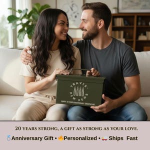 May include: An olive green metal ammunition box featuring a white graphic of four bullets arranged in a circle with the text "TRAVIS PEW PEWS" and "HAPPY 30 YEAR ANNIVERSARY SWEETHEART" printed on the front, equipped with a top carrying handle.