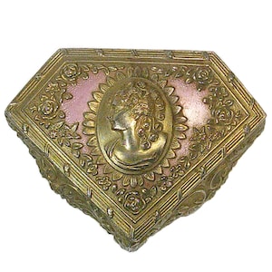 May include: An antique, diamond-shaped trinket box with a gold-colored metal frame. The box features a pink interior and a central medallion with a profile of a woman. Floral and leaf patterns adorn the box's exterior.