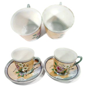 Pode incluir: Conjunto de quatro ch&aacute;venas de ch&aacute; e pires florais. As ch&aacute;venas e os pires s&atilde;o brancos com uma borda amarela clara e apresentam um desenho floral em rosa, verde e azul.