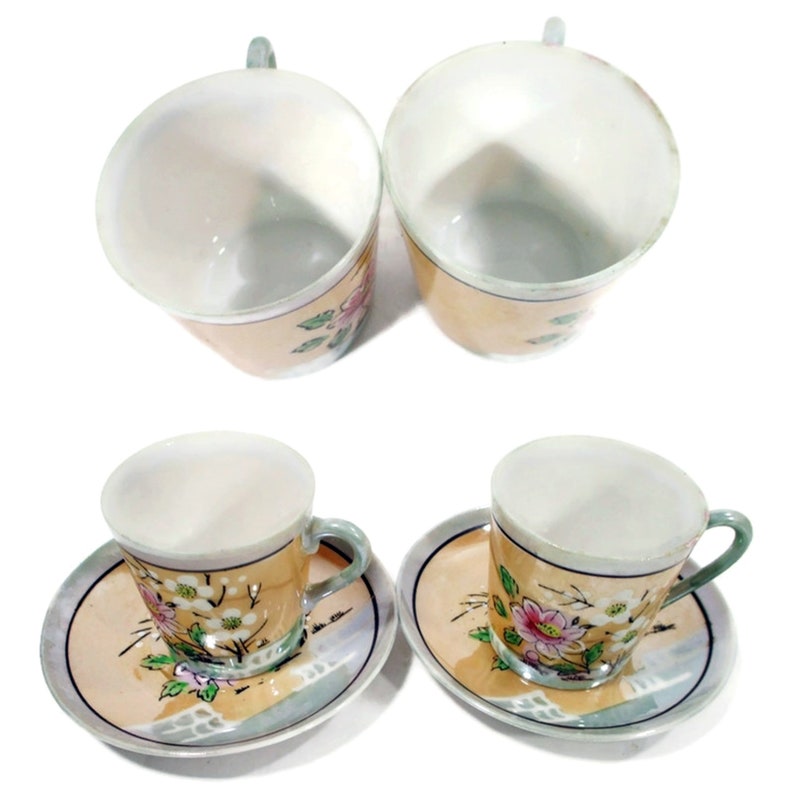 Pode incluir: Conjunto de quatro ch&aacute;venas de ch&aacute; e pires florais. As ch&aacute;venas e os pires s&atilde;o brancos com uma borda amarela clara e apresentam um desenho floral em rosa, verde e azul.
