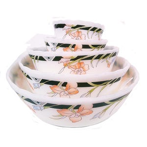 May include: Set of four white ceramic bowls with a black and green floral design. The bowls are nested inside each other.