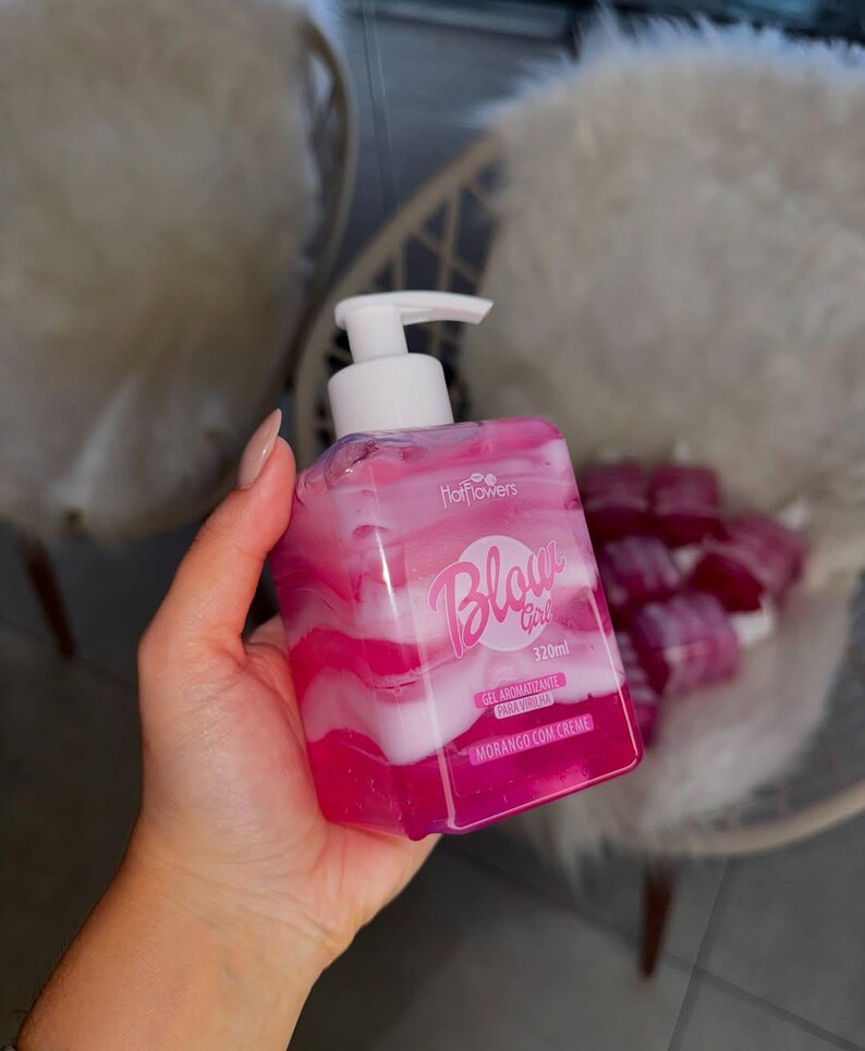 May include: Pink and white bottle of body wash with a pump dispenser. The bottle is labeled "Blow Girl" and "Morango com Creme".