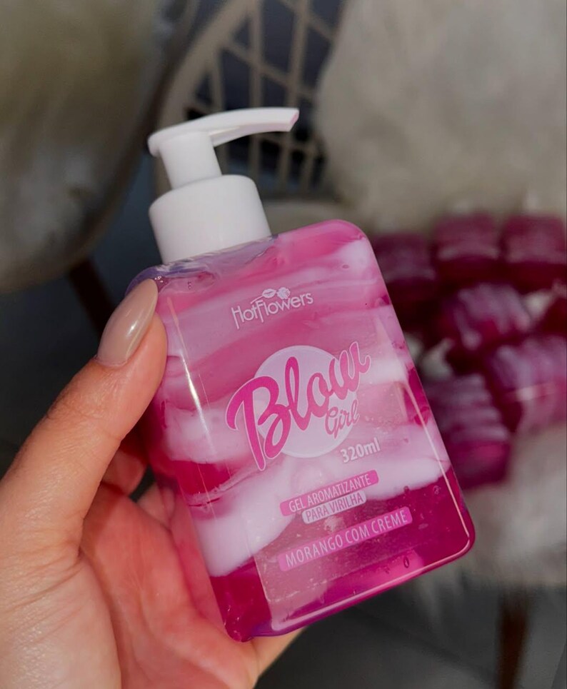 May include: A pink and white bottle of "Blow Girl" body gel with a pump dispenser. The bottle is labeled "Gel Aromatizante Para Virilha" and "Morango Com Creme" and contains 320 ml of product.
