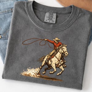 🤠 Houston Rodeo 2026 Shirt – Comfort Colors® 1717
Get rodeo-ready in true Texas style 🤎⭐
This Houston Rodeo 2026 Shirt is made for western moms, cowgirls, and rodeo lovers who live for boots, bucking horses, and arena nights.
With its retro southwestern vibe, this tee is perfect for rodeo season, country concerts, and everyday western fashion.
Design:
Features a vintage-inspired western graphic with bold rodeo energy — perfect for Houston Rodeo outfits, cowgirl aesthetics, and wild west vibes.