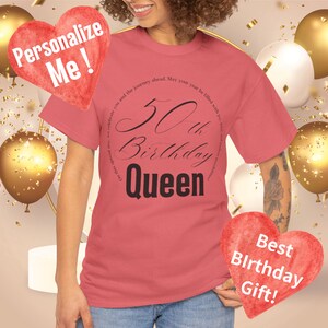 以下が含まれることがあります： 黒い円形のデザインが施された赤いTシャツで、「50th Birthday Queen」と円周に沿って引用文が書かれています。引用文は「この特別な日に、あなたとあなたを待ち受ける旅を祝います。あなたの年が…で満たされますように。」と書いてあります。Tシャツは女性の体に着用されています。右下隅には、「Best Birthday Gift!」と書かれた赤いハートがあります。