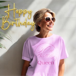 以下が含まれることがあります： サングラスをかけた女性と、「50th Birthday Queen」と書かれた薄いピンク色のTシャツ。背景には金色の「Happy Birthday」の風船文字があります。