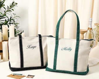 May include: Two canvas tote bags with black and green trim. The bag on the left has the name "Kaye" embroidered on it in black. The bag on the right has the name "Molly" embroidered on it in green.