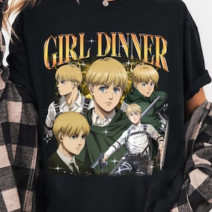 May include: Black long-sleeve shirt featuring a graphic of an anime character with the text "GIRL DINNER" in gold lettering. The graphic includes multiple images of the character in various poses. The shirt is a casual style.