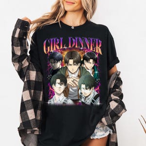 May include: Black t-shirt with a graphic print of anime characters. The text "GIRL DINNER" is printed in a colorful, retro font.