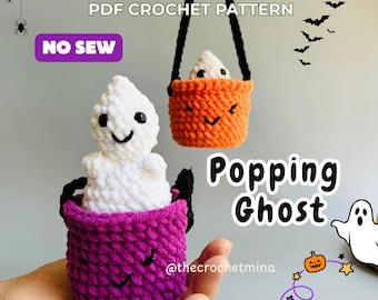 May include: A PDF crochet pattern for a Popping Ghost, featuring a white ghost plushie emerging from a purple or orange textured basket. The text reads PDF CROCHET PATTERN, NO SEW, Popping Ghost, and @thecrochetmina, with graphic illustrations of bats, spiders, and a pumpkin.