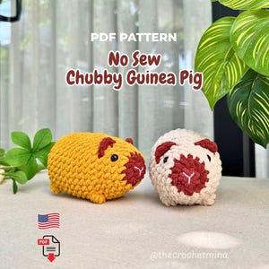 Puede incluir: Un patrón PDF para una cobaya regordeta sin costuras con dos cobayas de ganchillo. Una es de color amarillo mostaza con orejas y nariz rojo oscuro, y la otra es de color crema. El texto dice PDF PATTERN No Sew Chubby Guinea Pig.
