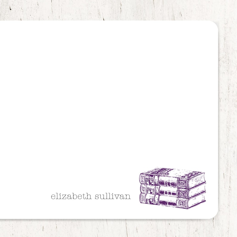May include: A white card with the text "elizabeth sullivan" printed in black at the bottom. A purple illustration of three stacked books is in the bottom right corner.