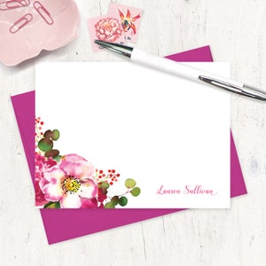 May include: White stationery card with a pink floral design in the bottom left corner. The card has the name "Lauren Sullivan" printed in pink script at the bottom right corner.