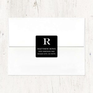 May include: Black and white return address label with the letter "R" in a large font, followed by the text "MATTHEW ROWE", "3869 HERITAGE WAY", and "SUGAR CITY, CO 81076".